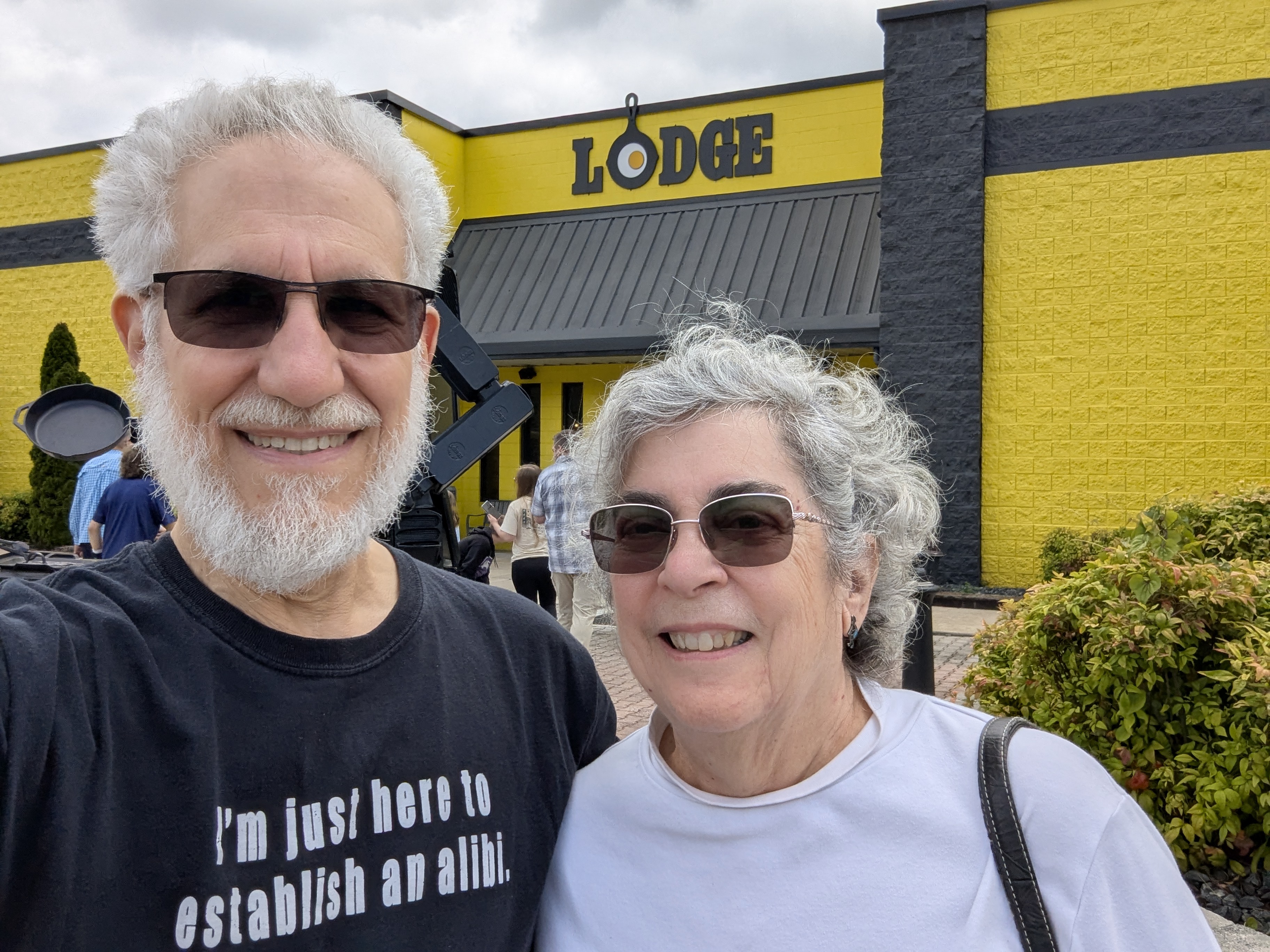 Art Zemon and Candy Zemon, standing in front of a yellow and grey wall with the Lodge company name on it