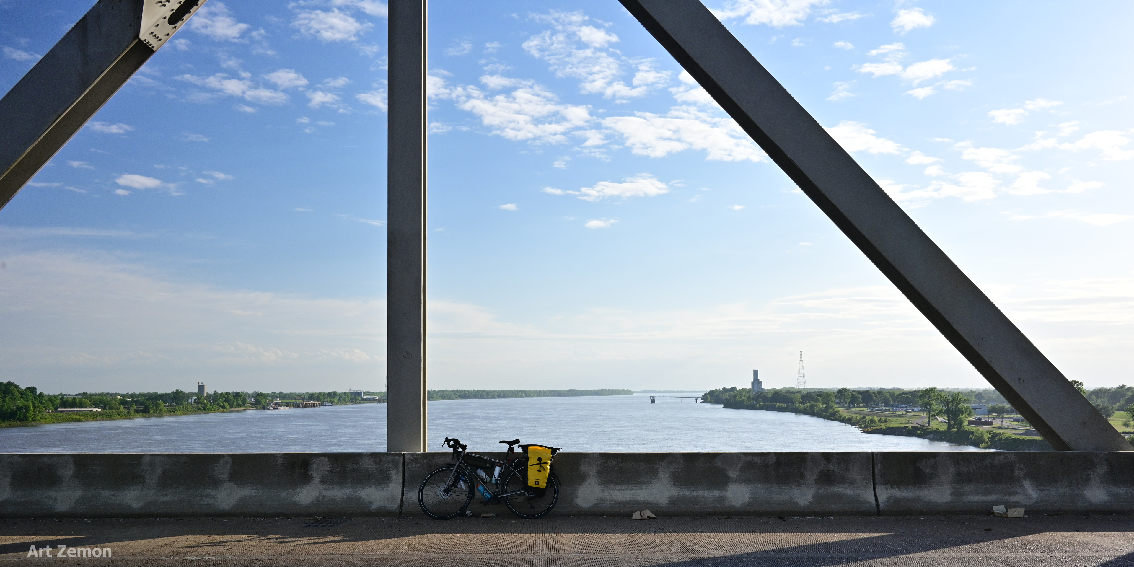 view of the Mississippi River from the bridge into Natchez, MS. there is a touring bicycle parked in the center