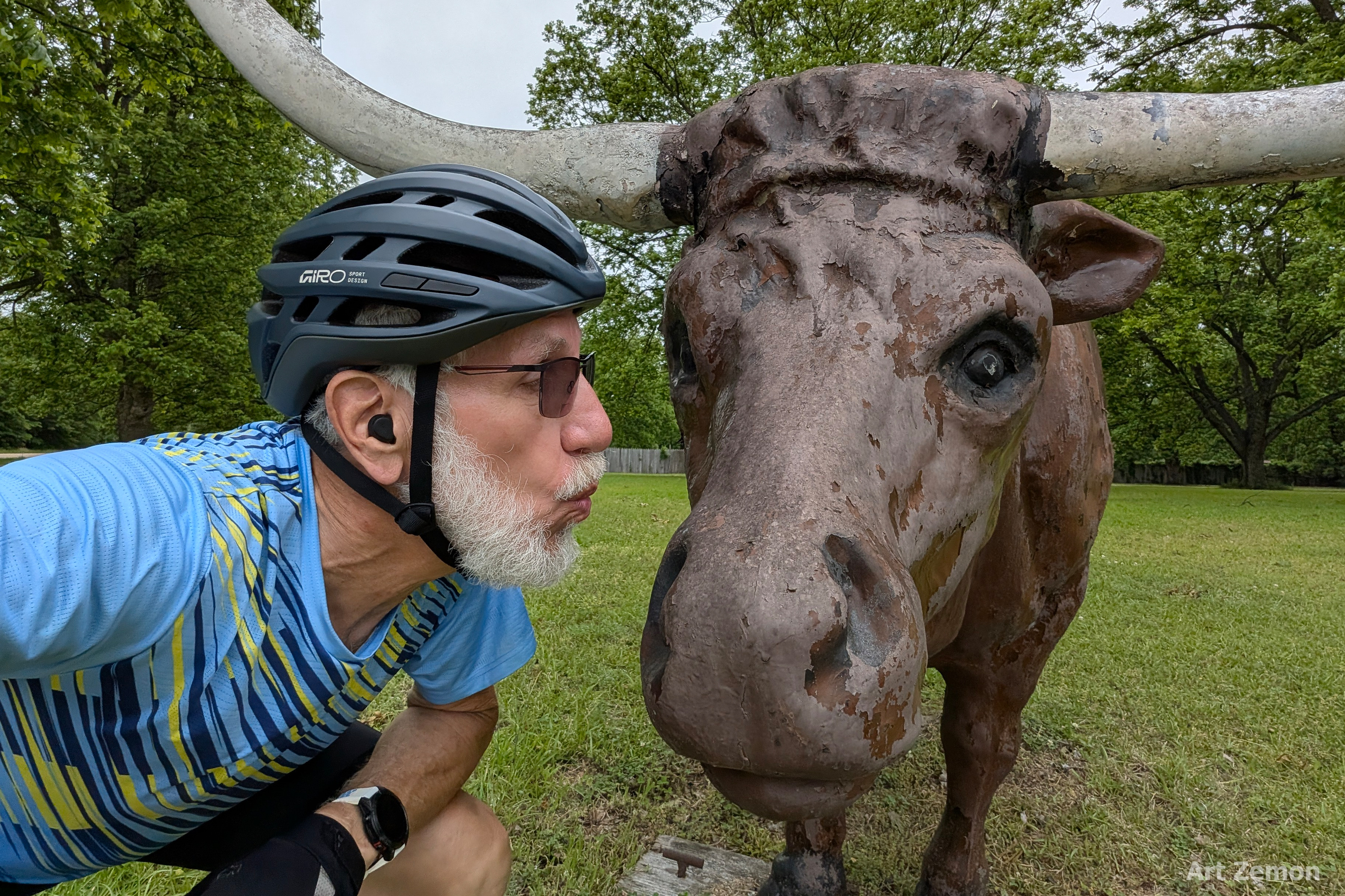 Art Zemon leaning forward to kiss a metal sculpted longhorn steer