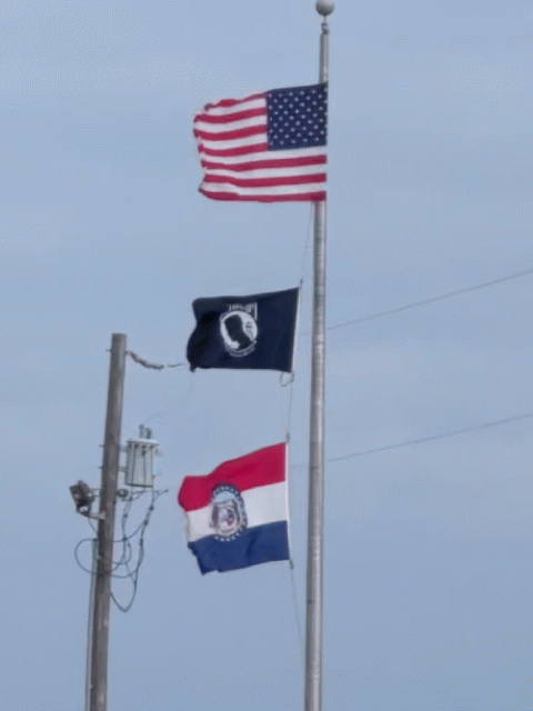 3 flags on a single pole, US, POW-MIA, and Missouri, all waving in very strong wind