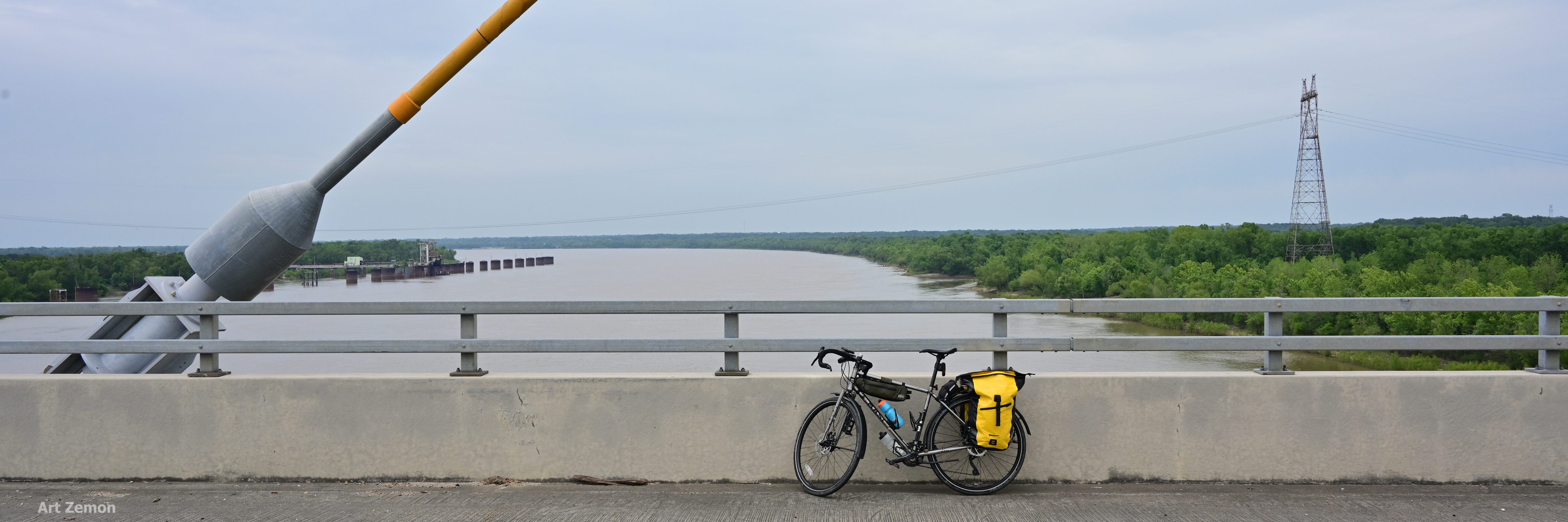 view of the Mississippi River looking north from the Audubon Bridge near New Roads, LA. There is a touring bicycle parked in the center